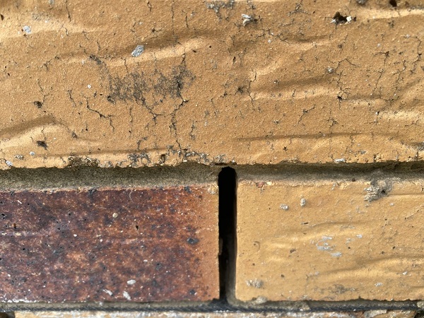 Weep hole in brickwork above damp course